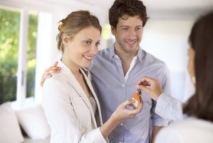 young couple taking house keys from real estate agent