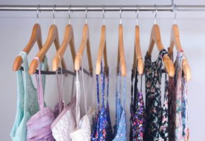 multiple female tops on hangers in a closet